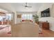 Spacious living room with hardwood floors, beige sofa, and access to patio at 906 Drakeswood Ave, The Villages, FL 32162