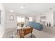 Combined dining and living area with teal sofa and glass dining table at 913 Allagash Ave, The Villages, FL 32162