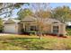 Tan one-story house with a white garage door and landscaping at 979 Princeton Dr, Clermont, FL 34711