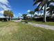 Spacious backyard featuring pool, lush green lawn and walkway at 100 Via Capri, New Smyrna Beach, FL 32169