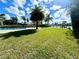 Expansive backyard features a lush lawn and waterfront views with a pool at 100 Via Capri, New Smyrna Beach, FL 32169