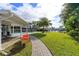 Landscaped backyard with a brick path leading to the pool and canal at 100 Via Capri, New Smyrna Beach, FL 32169