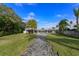 Landscaped backyard with a brick path leading to the pool and canal at 100 Via Capri, New Smyrna Beach, FL 32169