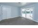 Carpeted bedroom features closet and sliding glass doors to the pool and lanai at 100 Via Capri, New Smyrna Beach, FL 32169