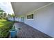 Gray-toned modern front porch with teal door and wood-like tile at 100 Via Capri, New Smyrna Beach, FL 32169