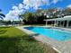 Inviting pool with brick pavers, dock, and lush green landscaping at 100 Via Capri, New Smyrna Beach, FL 32169