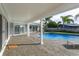 Relaxing covered patio adjacent to the refreshing blue swimming pool at 100 Via Capri, New Smyrna Beach, FL 32169