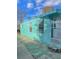 View of the teal mobile home's side entrance and additional yard space at 1005 Oakland St. St, Tavares, FL 32778