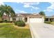 Tan single-story house with a two-car garage and manicured landscaping at 1149 Eureka Mill Run, The Villages, FL 32162