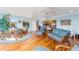 Sunroom with lake and partial kitchen view, wicker furniture, and wood floors at 1149 Eureka Mill Run, The Villages, FL 32162