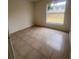 Simple bedroom with tile floors and a window offering a view of the yard at 11550 Foxglove Dr, Clermont, FL 34711