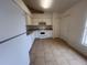 Galley-style kitchen with white cabinets and tile flooring at 11550 Foxglove Dr, Clermont, FL 34711