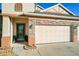 Three-car garage with stone accents and a green front door at 12532 Hammock Pointe Cir, Clermont, FL 34711