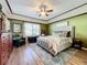 Main bedroom with king-size bed, wood floors, and an accent wall at 12532 Hammock Pointe Cir, Clermont, FL 34711