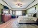 Main bedroom with king bed, wood floors, and an accent wall at 12532 Hammock Pointe Cir, Clermont, FL 34711