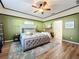 Main bedroom with wood floors, a king-size bed, and a ceiling fan at 12532 Hammock Pointe Cir, Clermont, FL 34711