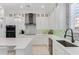 Modern white kitchen with stainless steel appliances and light-colored backsplash at 133 S Park Ave, Winter Garden, FL 34787