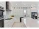 Modern white kitchen with stainless steel appliances and quartz countertops at 133 S Park Ave, Winter Garden, FL 34787