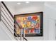 Modern staircase with metal railing and colorful artwork at 133 S Park Ave, Winter Garden, FL 34787