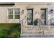 Two townhome entrances featuring gray doors, brick facade, and a shared staircase at 133 S Park Ave, Winter Garden, FL 34787