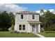 Two-story light green house with a teal door, small walkway, and landscaping at 16914 Hamlin Oasis Loop, Winter Garden, FL 34787