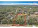 An aerial perspective of a property enveloped by dense woodland, edged by a bright red line at 1701 Cedar Stone Ct, Lake Mary, FL 32746