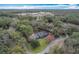 Expansive aerial view showing the home's setting amidst a dense forest and nearby buildings at 1701 Cedar Stone Ct, Lake Mary, FL 32746