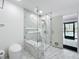 Modern bathroom featuring a glass shower with bench and marble walls, and a toilet at 1701 Cedar Stone Ct, Lake Mary, FL 32746