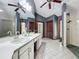 Bright bathroom featuring double sinks, ceiling fans, walk-in shower and gray tile floors at 1701 Cedar Stone Ct, Lake Mary, FL 32746