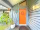 Welcoming covered front entrance with gray siding and a bright orange door at 1701 Cedar Stone Ct, Lake Mary, FL 32746