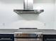 Close-up of a modern stove with stainless steel KitchenAid vent hood and sleek dark countertops at 1701 Cedar Stone Ct, Lake Mary, FL 32746