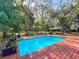 Backyard oasis featuring a sparkling pool, wood deck, and lush landscaping at 1701 Cedar Stone Ct, Lake Mary, FL 32746