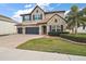 Two-story house with stone accents and a three-car garage at 17889 Gourd Neck Loop, Winter Garden, FL 34787