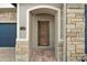 Elegant wood front door with stone entryway at 17889 Gourd Neck Loop, Winter Garden, FL 34787