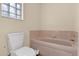 Bathroom with pink tile and built in tub at 1916 Antonia Pl, The Villages, FL 32159