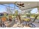 Relaxing screened porch with seating area and ceiling fan at 1916 Antonia Pl, The Villages, FL 32159