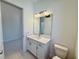 Bathroom with single vanity, quartz countertop, and a view of a hallway at 2022 Wallingford Loop, Mount Dora, FL 32757