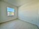 Bright bedroom with large window and neutral-toned flooring at 2022 Wallingford Loop, Mount Dora, FL 32757