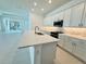 Modern kitchen with white cabinets, quartz countertops, and stainless steel appliances at 2022 Wallingford Loop, Mount Dora, FL 32757