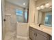 Modern bathroom featuring a single vanity, shower stall with glass enclosure, and a large mirror at 2046 Wallingford Loop, Mount Dora, FL 32757