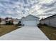 Light blue house exterior with a two-car garage and a landscaped lawn at 2046 Wallingford Loop, Mount Dora, FL 32757