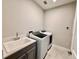 Laundry room with washer, dryer, and utility sink, offering ample space at 2046 Wallingford Loop, Mount Dora, FL 32757