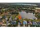 Aerial view of a house near a lake with a large backyard and a three-car garage at 2054 Vision Ct, The Villages, FL 32163