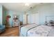 Charming bedroom with light blue walls, wood floors, and antique-style wooden furniture at 2054 Vision Ct, The Villages, FL 32163