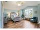 Bright bedroom with wood flooring, a comfy chair, and a ceiling fan at 2054 Vision Ct, The Villages, FL 32163