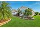 Well-maintained landscaping, inviting entryway, and palm trees at 2054 Vision Ct, The Villages, FL 32163