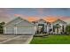 Beautiful home with three-car garage, landscaping, and sunset view at 2054 Vision Ct, The Villages, FL 32163