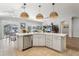 Large kitchen island with white cabinets and stainless steel dishwasher, overlooking living room at 2054 Vision Ct, The Villages, FL 32163