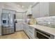 Modern kitchen with gray cabinets, stainless steel appliances, and tile flooring at 2054 Vision Ct, The Villages, FL 32163