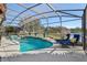 Screened pool and spa with lounge chairs and tranquil view at 2054 Vision Ct, The Villages, FL 32163